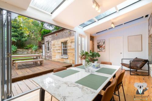 a dining room with a table and a patio at KozyGuru | Balmain | Charming 3 Room cottage in Sydney