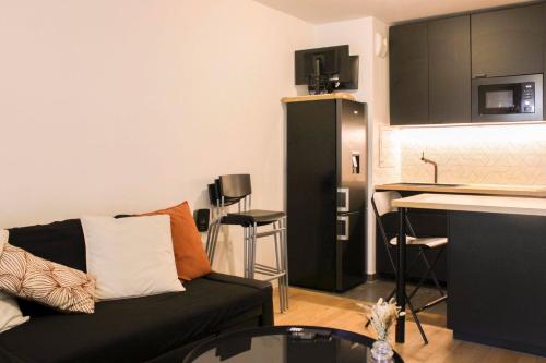un salon avec un canapé et une cuisine dans l'établissement Beautiful 1-bedroom apartment with terrace, à Boulogne-Billancourt