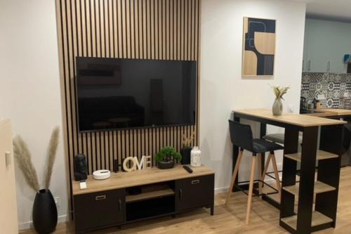 un salon avec une grande télévision et une table dans l'établissement Charming studio for two in Mandelieu-la-Napoule, à Mandelieu-la-Napoule