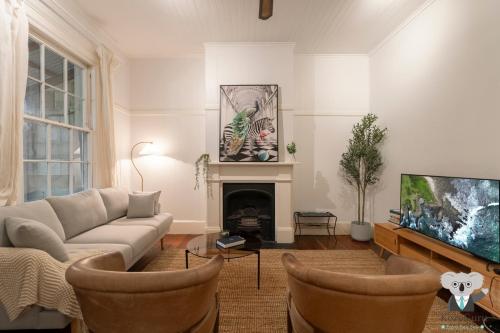 a living room with a couch and a fireplace at KozyGuru | Balmain | Charming 3 Room cottage in Sydney