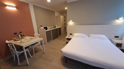 San PoloにあるDUCATO HOTEL e RESIDENCEのベッドとテーブルとキッチンのある寝室