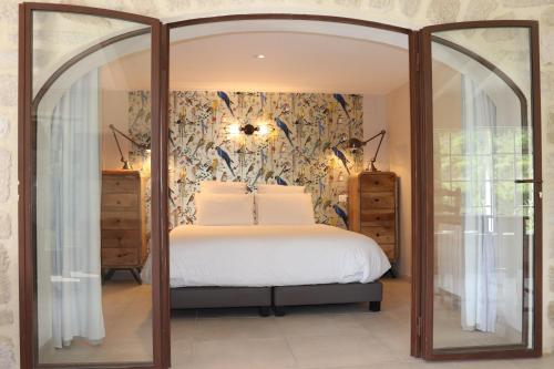 une chambre avec un lit et un grand miroir dans l'établissement Les Terrasses de la Roque-Alric, à La Roque-Alric