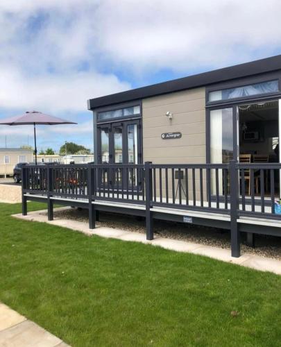 a mobile home with a black roof and windows at caravan to let in Ingoldmells