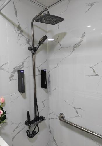 a shower with a shower head in a bathroom at Le Paradise Palace Hotel Deira Dubai Al Rigga in Dubai
