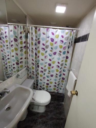 a bathroom with a toilet and a sink at Hotel Cano in Iquique
