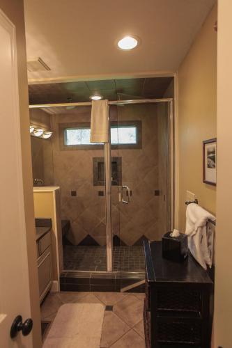 a bathroom with a shower with a glass door at Couples Paradise I - by The Chalets in Logan