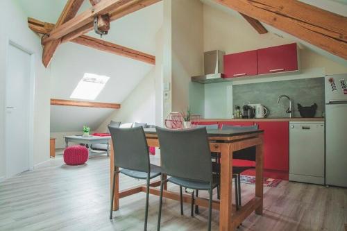 une cuisine avec une table et des chaises dans une pièce dans l'établissement Le Mil charmant T2 proche de Geneve, à Beaumont