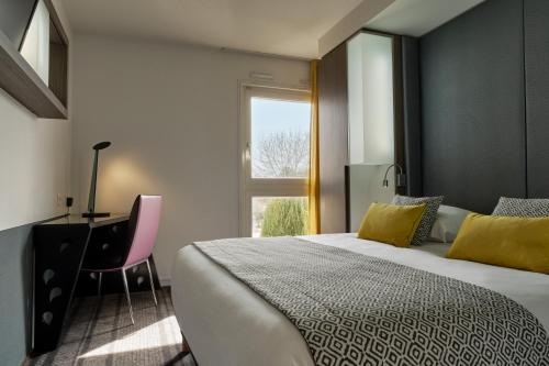 a bedroom with a bed and a desk and a window at Hotel Restaurant Crystal in Erstein