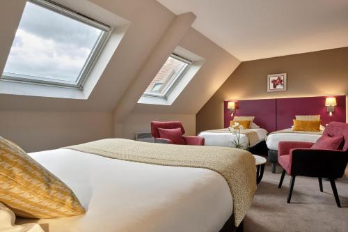 two beds in a room with two windows at Hotel Restaurant Crystal in Erstein