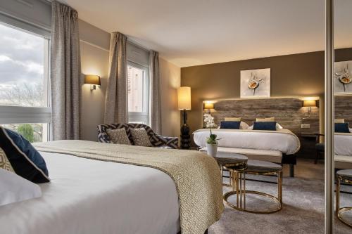a hotel room with two beds and a table at Hotel Restaurant Crystal in Erstein