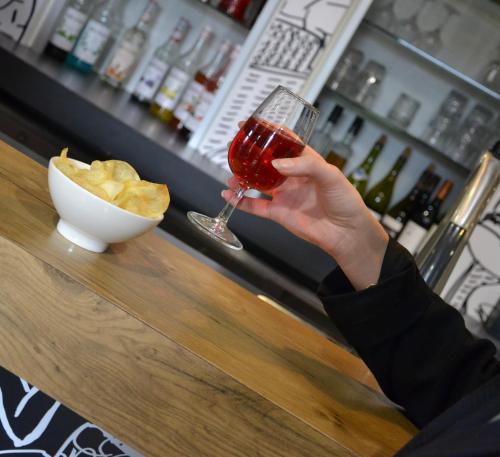 a person holding up a glass of wine at a bar at ibis Chambery in Chambéry