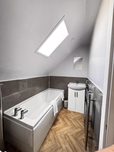 a bathroom with a large bath tub and a skylight at Mill House Retreat in Leslie