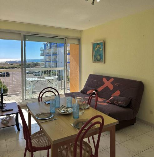 un salon avec une table et un canapé dans l'établissement Appartement vue port et mer-4PPII26, au Barcarès