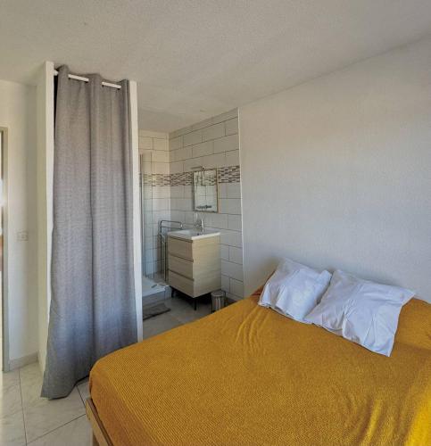 une chambre avec un lit et une salle de bain avec un lavabo dans l'établissement Appartement vue port et mer-4PPII26, au Barcarès