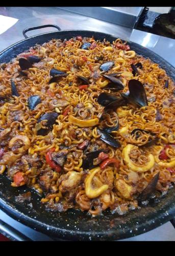 a pan filled with noodles and other ingrediants at Hotel Nuevo Ondina in Begur