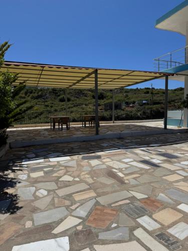 two benches sitting under a pavillion with a roof at Hotel Irini in Sarandë