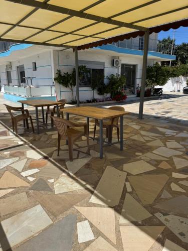 a table and chairs under an umbrella on a patio at Hotel Irini in Sarandë