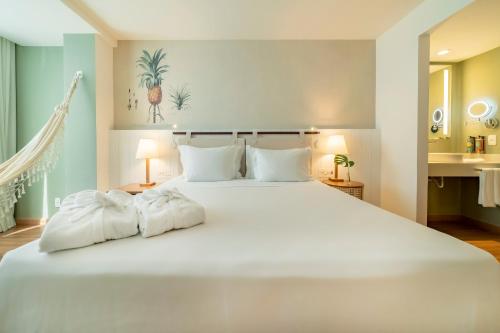a bedroom with a large white bed with two pillows at Grand Mercure Rio de Janeiro Copacabana in Rio de Janeiro
