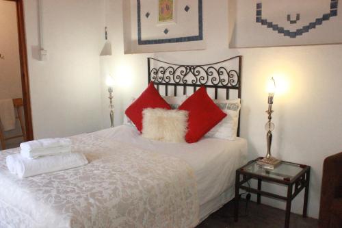 a bedroom with a bed with red and white pillows at Soli Deo Gloria in McGregor
