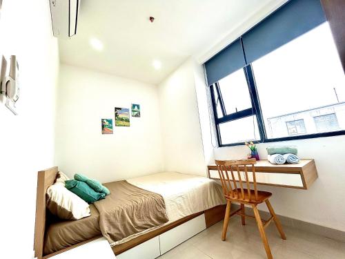 une petite chambre avec un lit et un bureau dans l'établissement Tom's House 2 Apartment, à Thôn Văn Dương