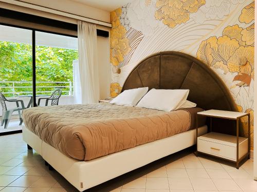 a bedroom with a large bed with a floral wall at Hotel President - Vintage Hotel in centro in Riccione