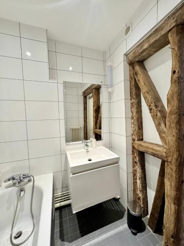 une salle de bain avec un lavabo, une baignoire et un miroir dans l'établissement Le Saint Michel, Hyper centre de Rennes, à Rennes
