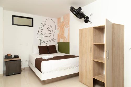 a bedroom with a bed with a painting on the wall at Bajo la luna hotel in Medellín