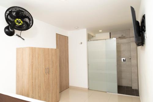 a room with a door and a fan on the wall at Bajo la luna hotel in Medellín