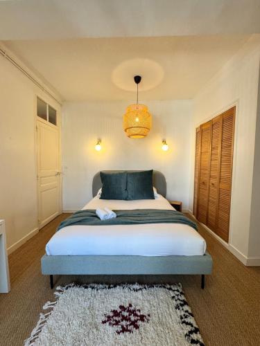 une chambre avec un grand lit et un lustre dans l'établissement Le Saint Michel, Hyper centre de Rennes, à Rennes