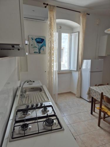 a kitchen with a stove top oven next to a window at Casa Aurora in Polignano a Mare