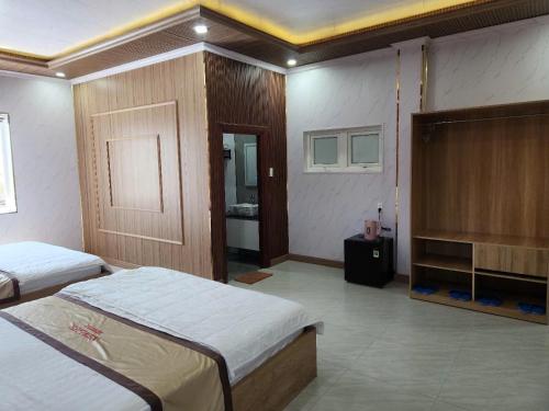 a hotel room with two beds and a bathroom at New Life Homestay in Phan Thiet