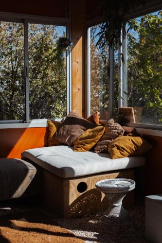 a bed sitting in a room with windows at DE BUITENKANS urban camping - unique cabins in Rotterdam