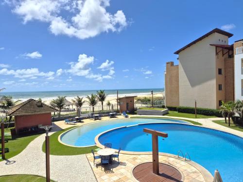 a swimming pool with the beach in the background at TerraMaris - Pé na Areia e Vista Mar Deslumbrante in Aquiraz