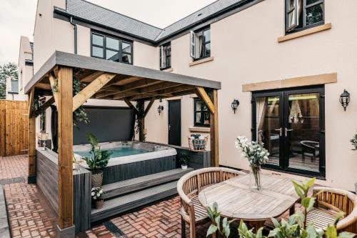 a patio with a hot tub and a wooden pergola at South Causey Inn in Stanley