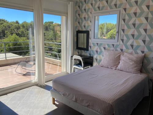 une chambre avec un lit et un balcon dans l'établissement Somptueuse Villa d'architecte climatisée avec Piscine chauffée, à Bandol