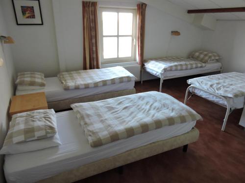 a room with three beds and a window at Vakantiehuisjes Op De Horst in Groesbeek
