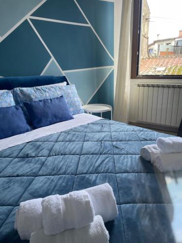 a blue bedroom with a bed with towels on it at La dimora di Sandy in Viterbo