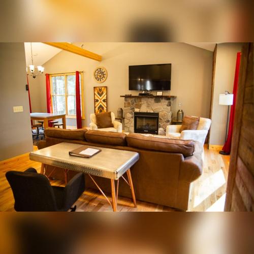 a living room with a couch and a fireplace at Evergreen - by The Chalets in Laurelville