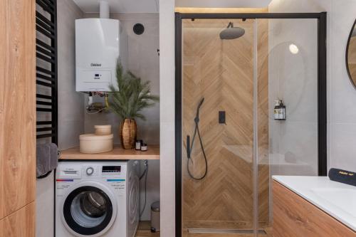 een badkamer met een wasmachine en een douche bij Cozy Corner by Cozyplace in Krakau
