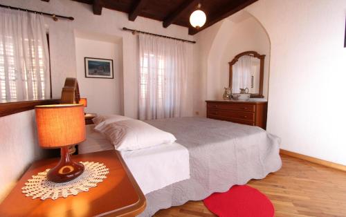 1 dormitorio con 1 cama y 1 mesa con lámpara en Apartments Ive, en Rovinj