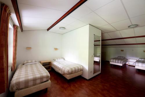 a hotel room with two beds and a mirror at Vakantiehuisjes Op De Horst in Groesbeek