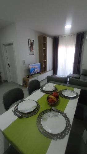 a living room with a table with plates on it at Golem Horizon apartment in Golem