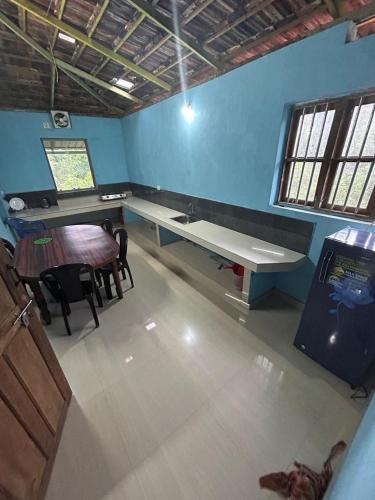 a room with a desk and a table and chairs at Rifa homestay in Kalpetta