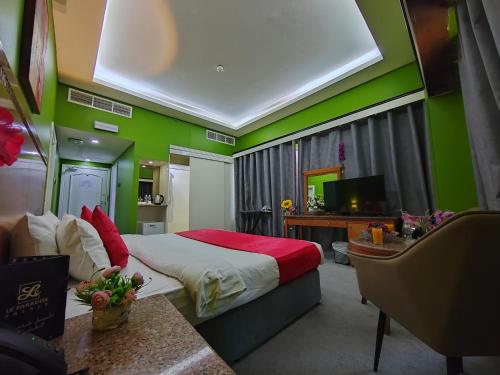 a bedroom with green walls and a bed and a desk at Le Paradise Palace Hotel Deira Dubai Al Rigga in Dubai