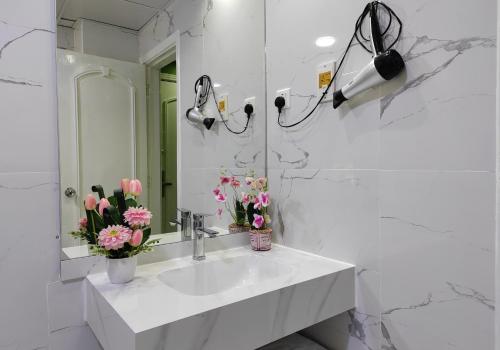a white bathroom with a sink and a mirror at Le Paradise Palace Hotel Deira Dubai Al Rigga in Dubai