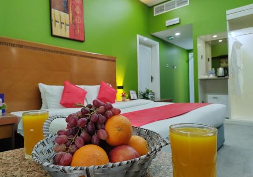 a bowl of fruit on a table next to a bed at Le Paradise Palace Hotel Deira Dubai Al Rigga in Dubai