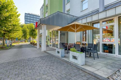 a restaurant with a table and umbrella on a street at ibis Hotel Frankfurt Messe West in Frankfurt