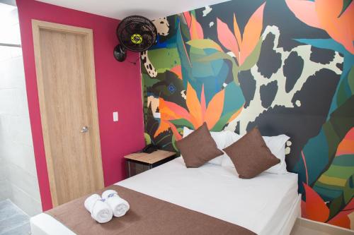 a bedroom with a bed with a colorful wall at Bajo la luna hotel in Medellín