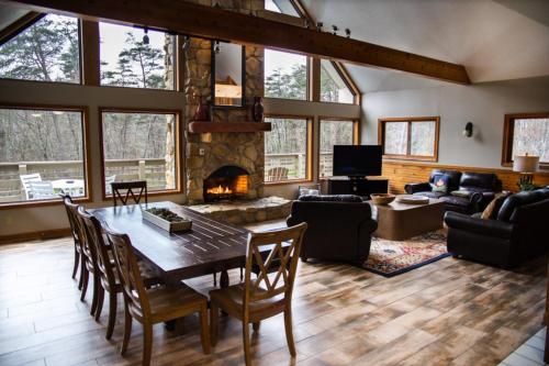 a living room with a table and a fireplace at Fireside Lodge - by The Chalets in Logan