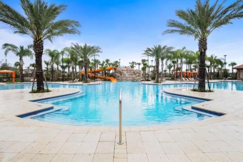 a pool at a resort with palm trees and a slide at Luxurious Townhome in Solterra Resort - SOLT01 in Davenport